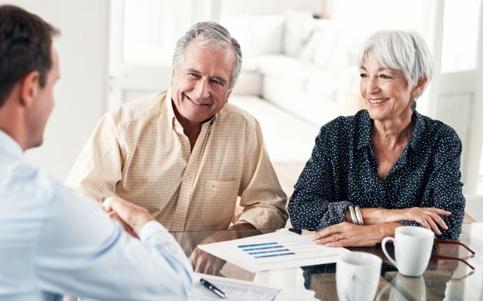 An IncredibleBank financial advisor providing personalized guidance to a couple with financial documents at the table.